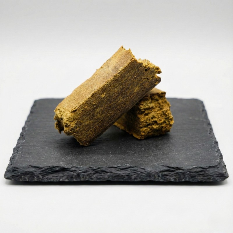 Dry Hash CBD bio haute qualité sur présentoir en ardoise. Résine de chanvre naturelle et dense