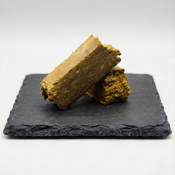 Dry Hash CBD bio haute qualité sur présentoir en ardoise. Résine de chanvre naturelle et dense